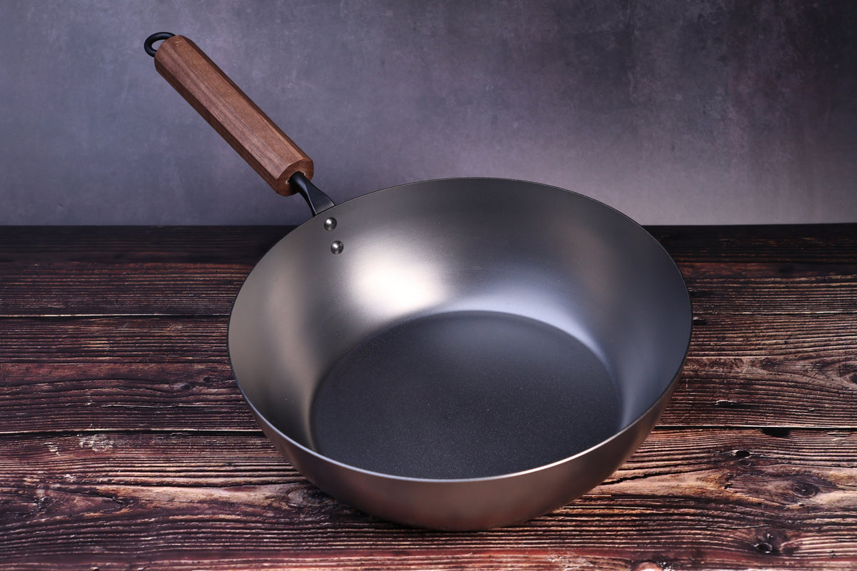 Carbon Steel Nitride deep fry pan 26cm showing dark nitride interior and walnut handle on wood surface