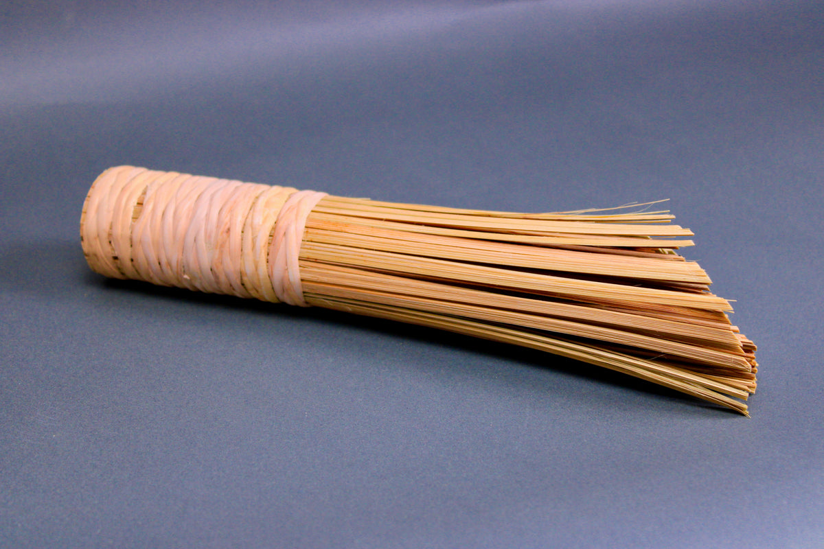 wide short woven bamboo brush thick sturdy beveled edge atop dark grey background
