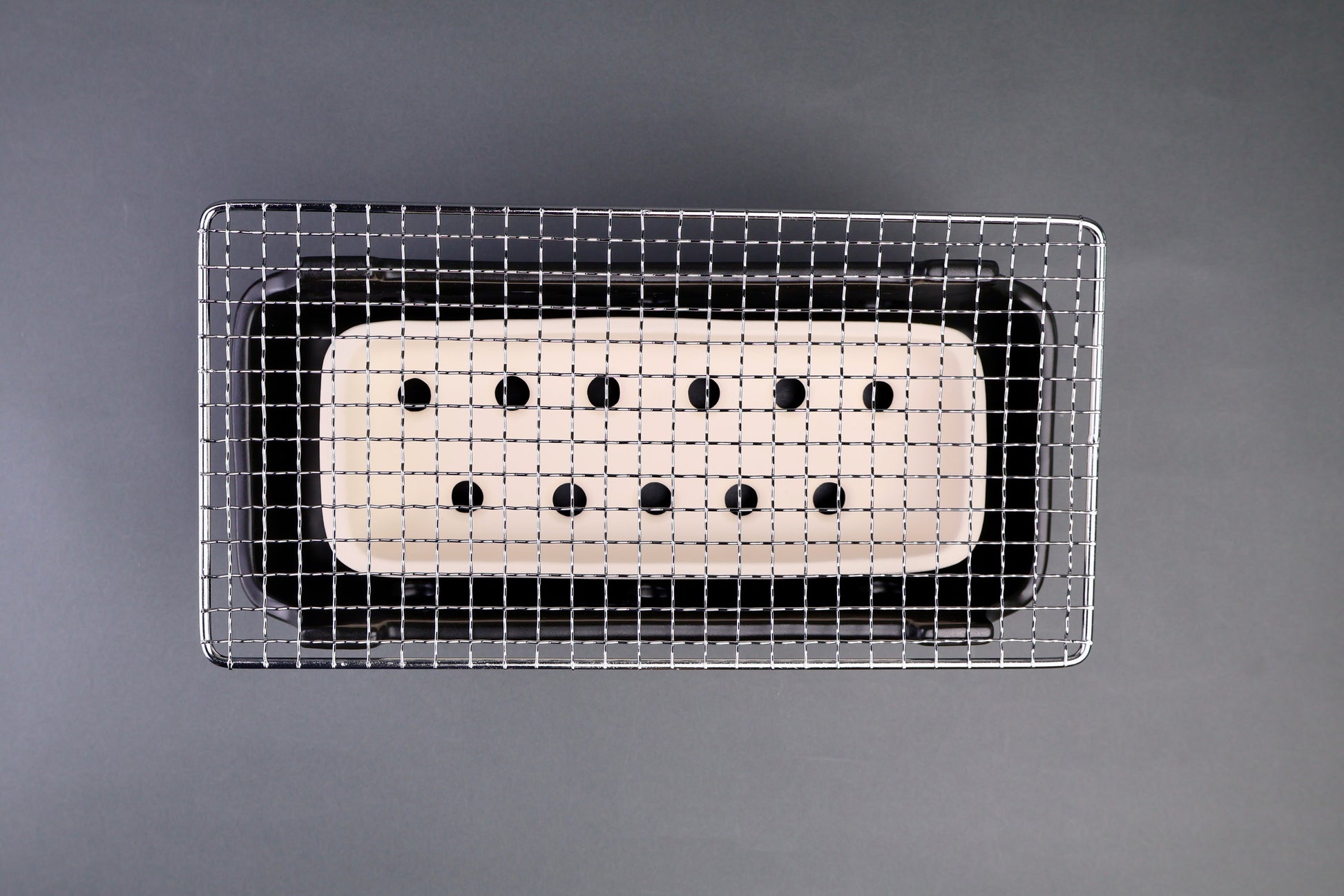 long rectangular black white ceramic stainless steel grill in grey backdrop 