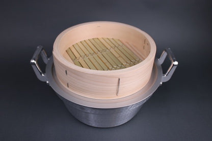 close up shot of seiro pot with steam ring thick handmade bamboo steamer base kiso hinoki and grey background