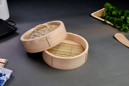 detailed close up shot of seiro hinoki bamboo steamer surrounded by parsley bamboo mat grill and sarashi grey background
