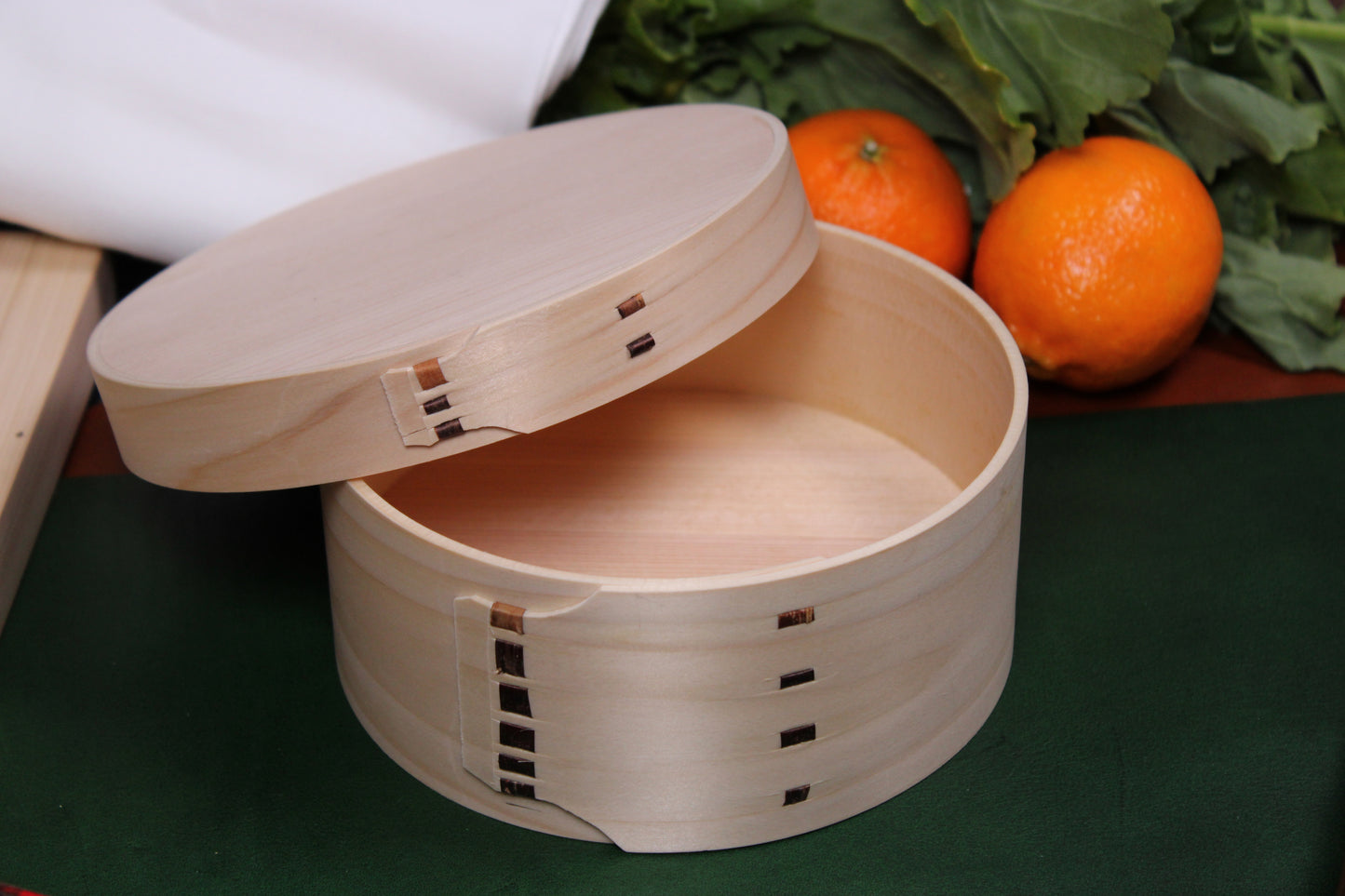 japanese washoku rice container ohitsu with lid off beside kitchenware and vegetables