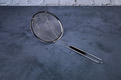 Coarse mesh skimmer — full view showing wire mesh basket, rim, and stainless handle on concrete