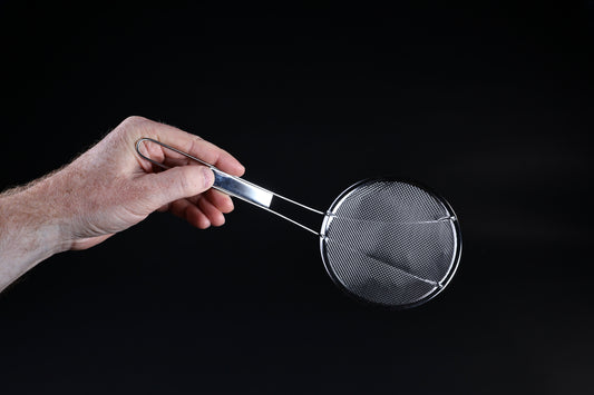 Coarse mesh skimmer — face-on view of wire mesh basket and stainless rim held in hand