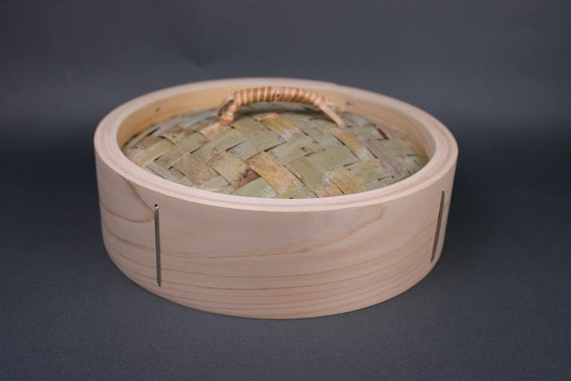 bamboo hinoki chinese handmade steamer lid showing top with woven bamboo and rattan handle with grey background