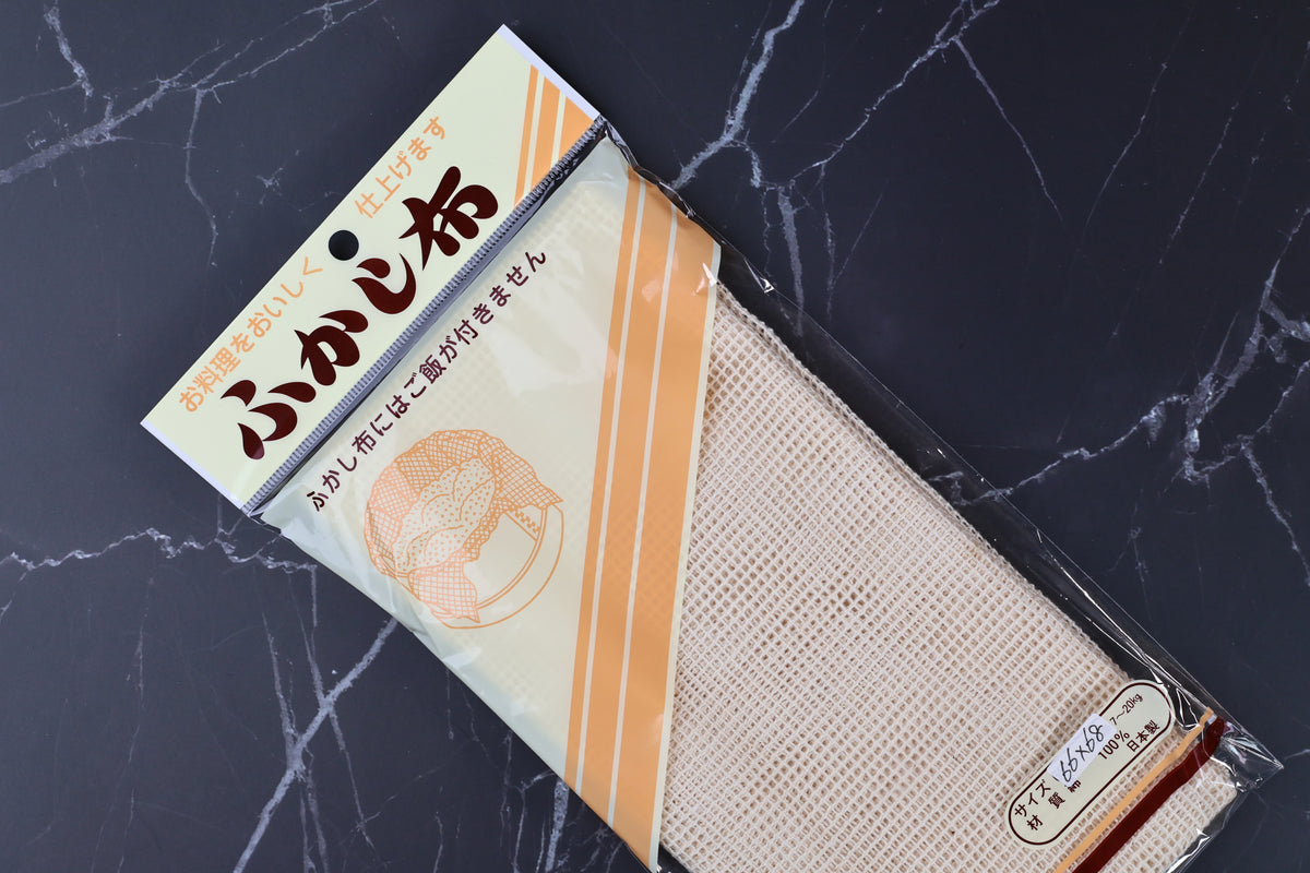 Cotton steamer cloth fukashi 66x68cm — angled view showing open-weave cotton mesh texture with packaging label