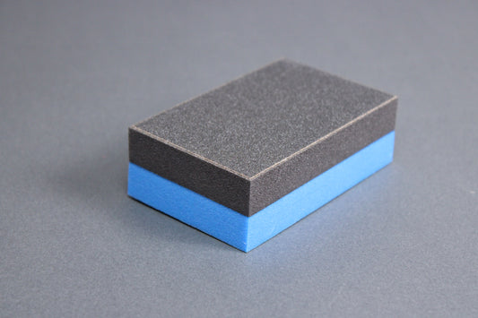 blue black toned rectangular block shaped cutting board scraper grey background 