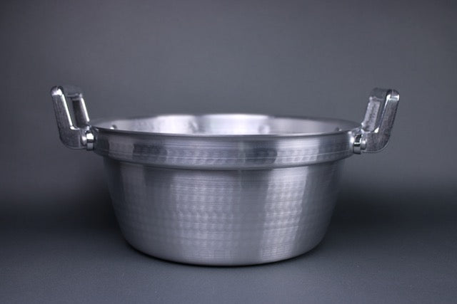  level view steaming pot with two handles stepped ledge for steam basket hammered surface with grey background