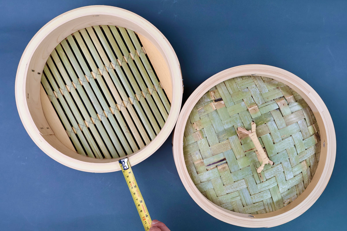 Overhead view of Ebematsu Shoji 27cm kiso hinoki bamboo steamer base and lid with tape measure showing internal diameter