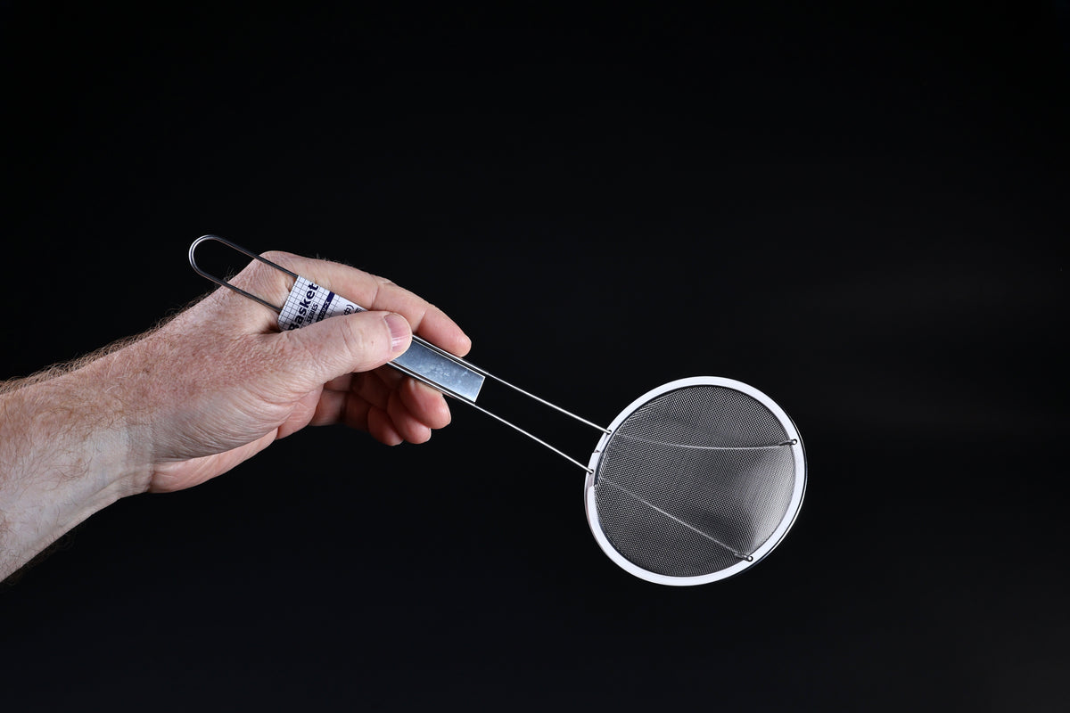 Fine mesh skimmer — face-on view of fine wire mesh basket and stainless rim held in hand