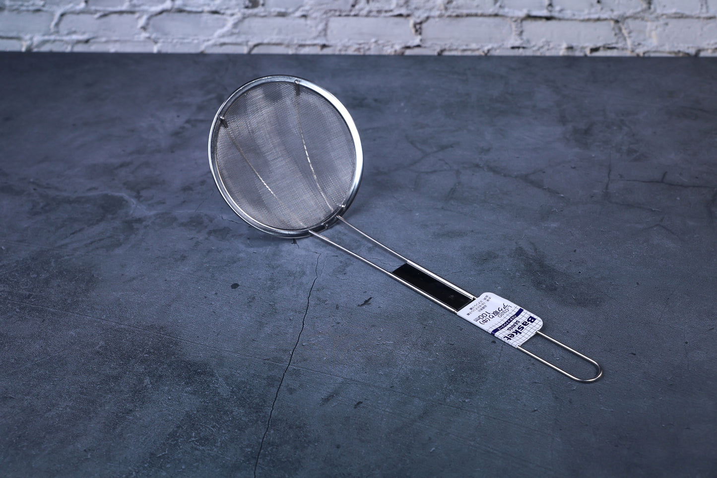 Fine mesh skimmer — full view showing fine wire mesh basket, stainless rim, and Japanese product label