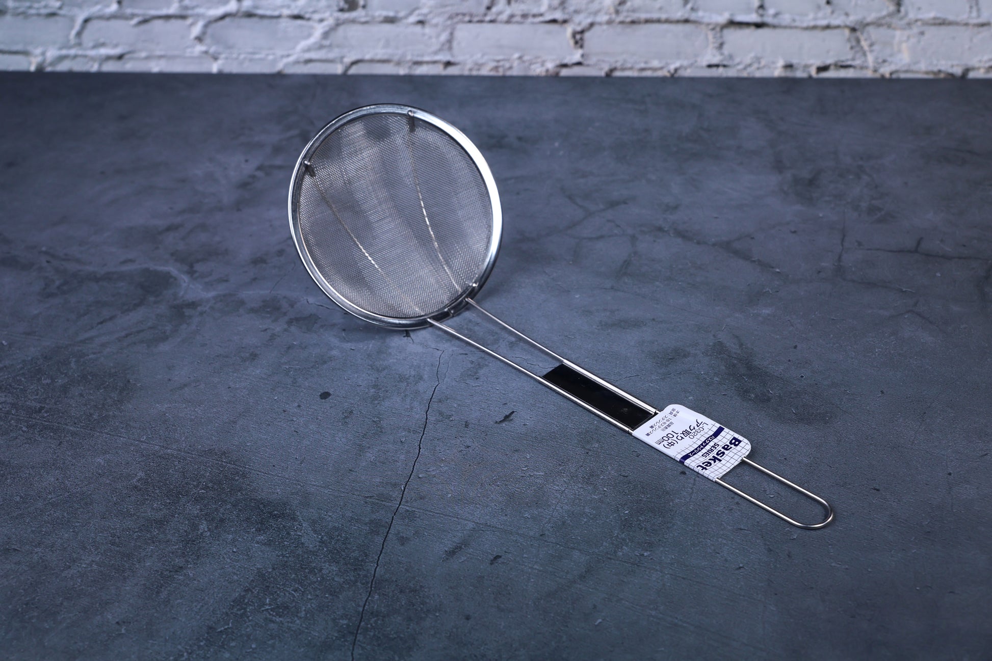 Fine mesh skimmer — full view showing fine wire mesh basket, stainless rim, and Japanese product label