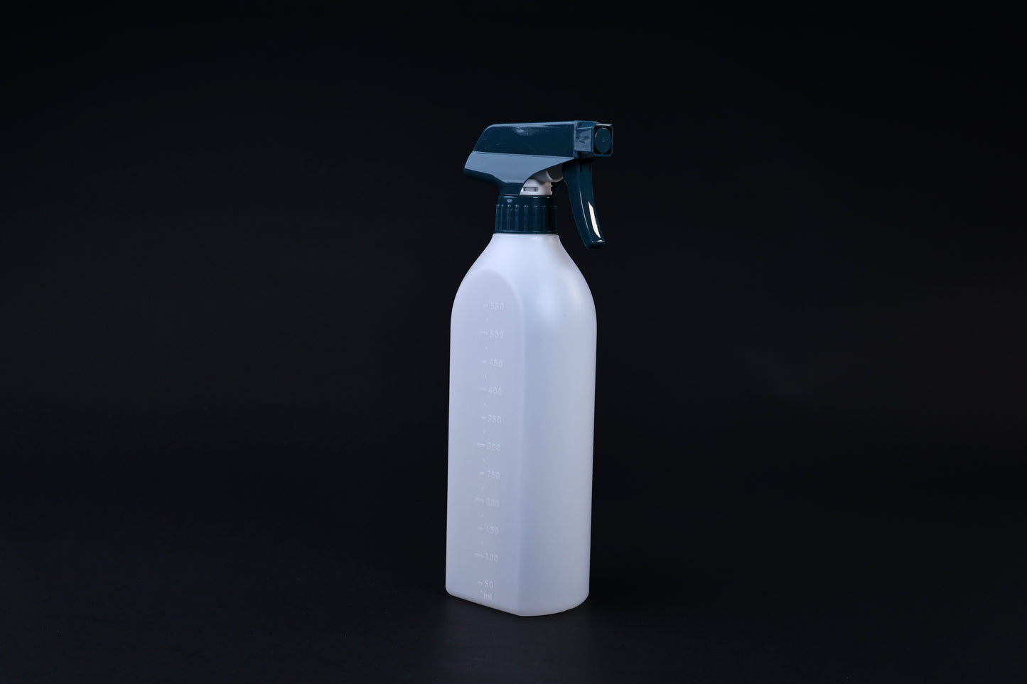 Flat-sided spray bottle standing upright on black background, teal trigger head and embossed volume markings