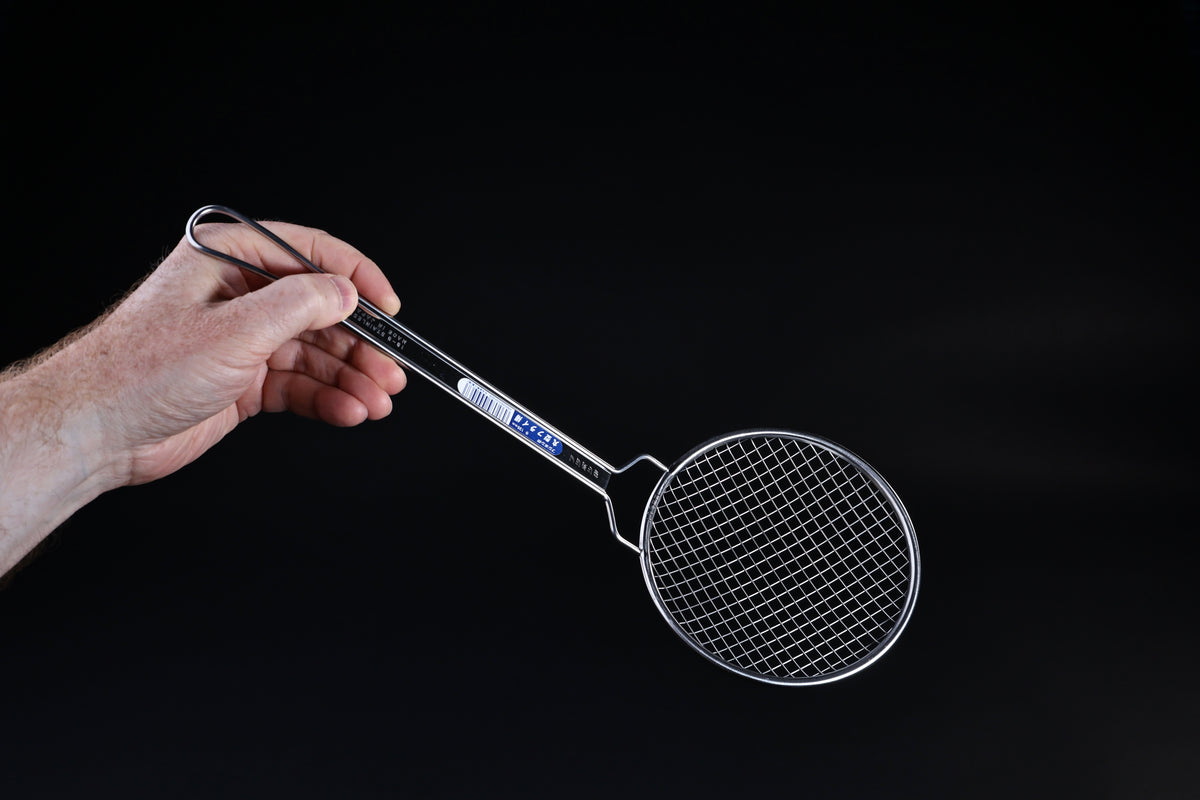 Fujiboshi fried food skimmer — face-on view of wire grid basket and long stainless handle held in hand