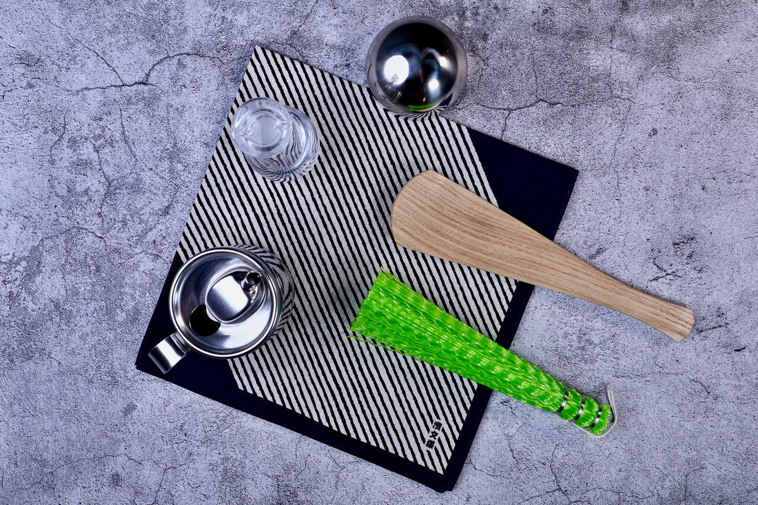 Hamamonyo classified stripes black tenugui styled on concrete with kitchen tools, showing real-use context