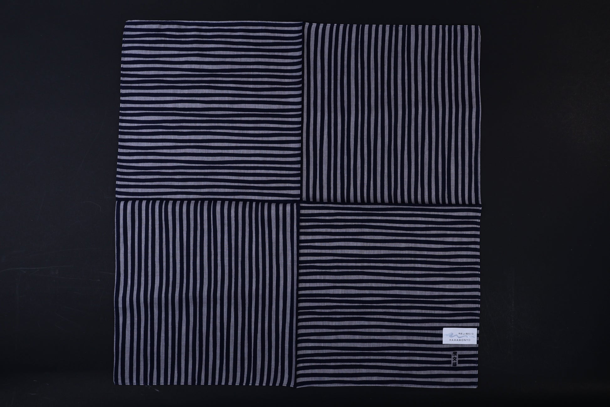 Hamamonyo tateyoko striped tenugui fully unfolded on black background, showing four-panel stripe pattern variation