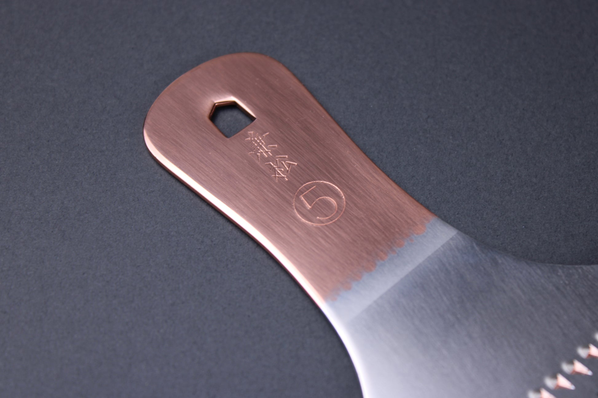 closeup of copper handle showing kanji and number five of japanese copper grater  