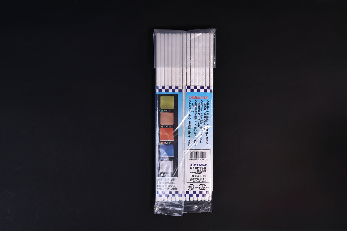 Back of the Hasegawa white sushi rolling mat size S package laid flat on a dark background
