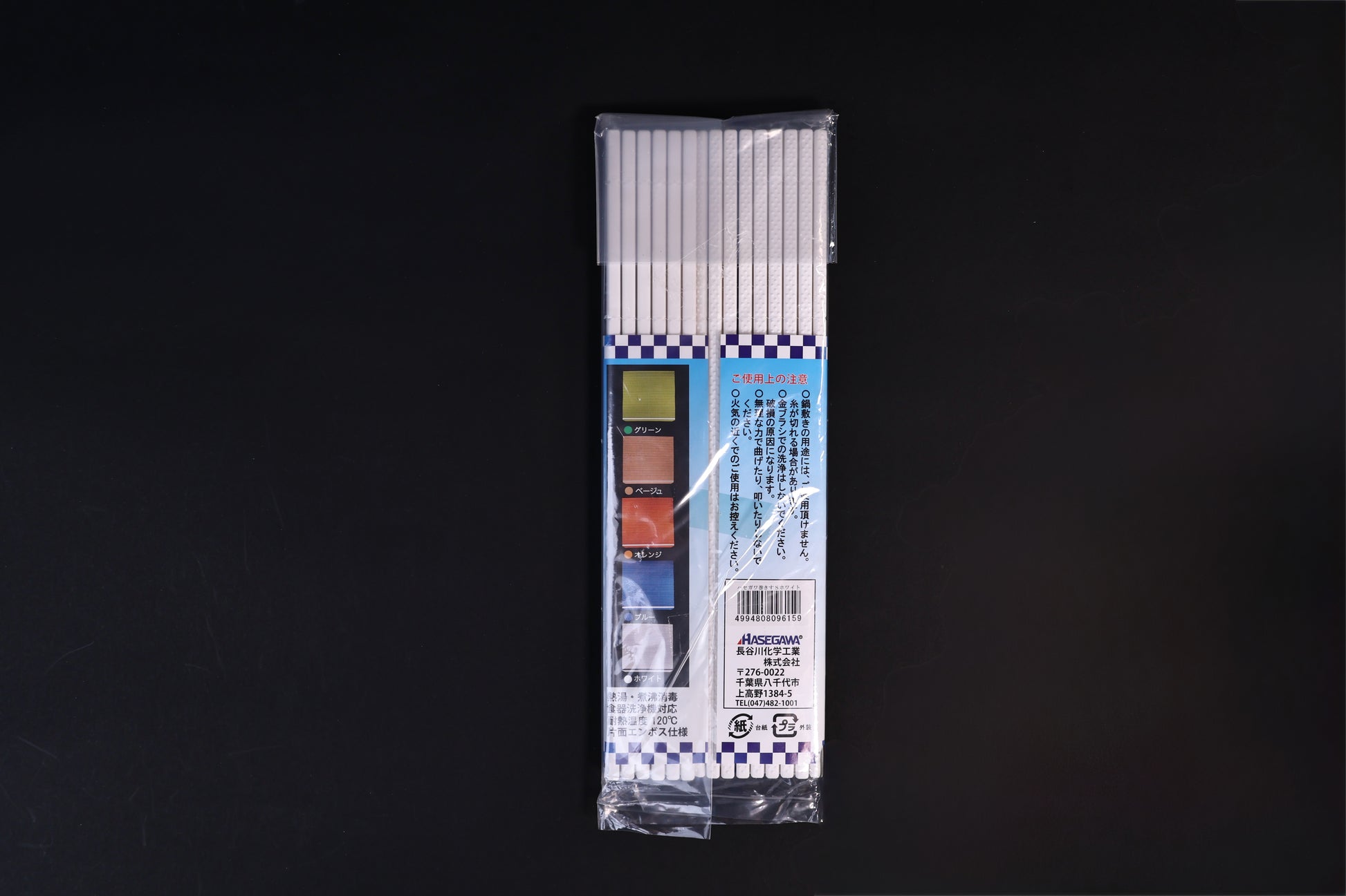 Back of the Hasegawa white sushi rolling mat size S package laid flat on a dark background
