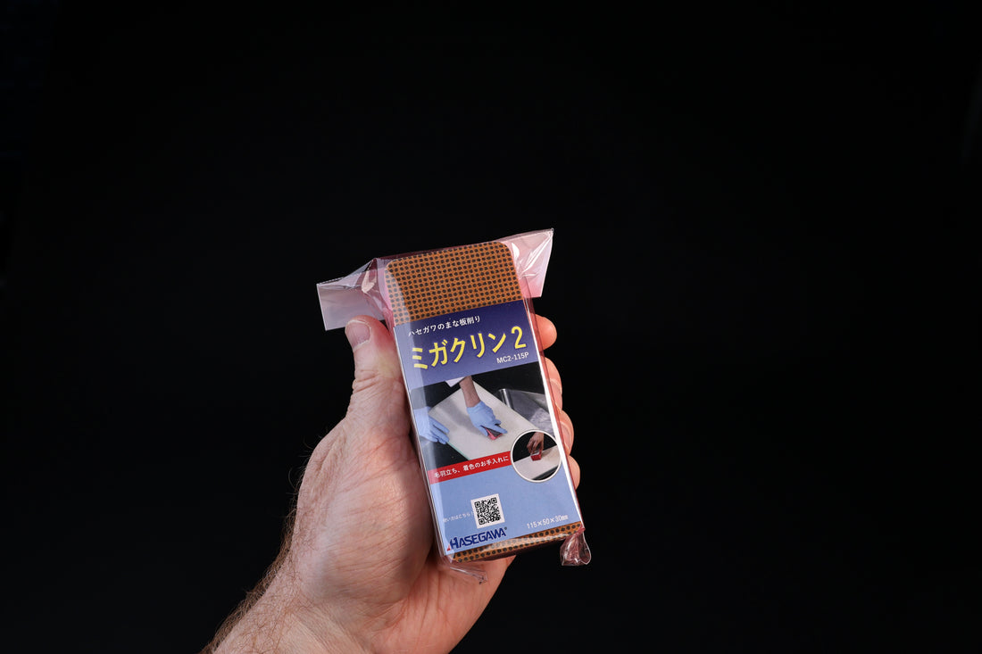 Hasegawa Migakurin 2 cutting board scraper — front of Japanese retail packaging held in hand