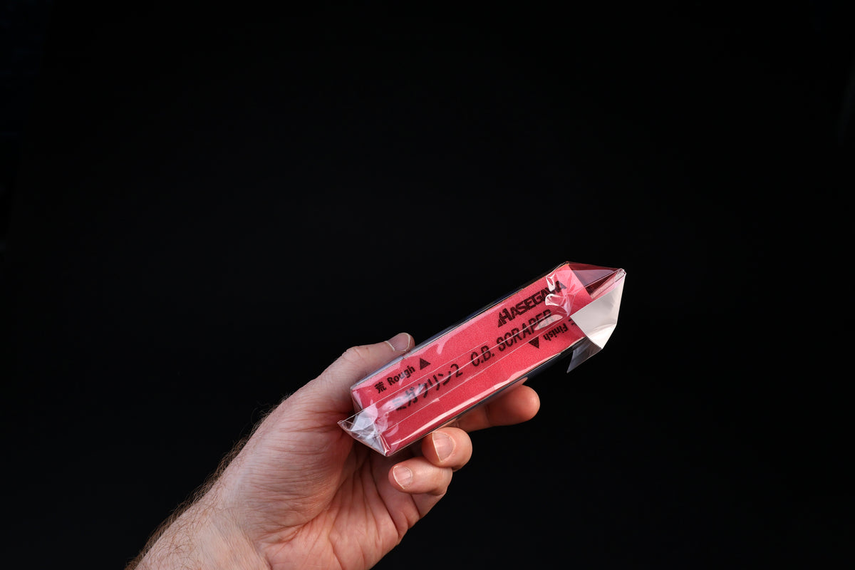 Hasegawa Migakurin 2 cutting board scraper — side profile in hand showing rough and finish face labels