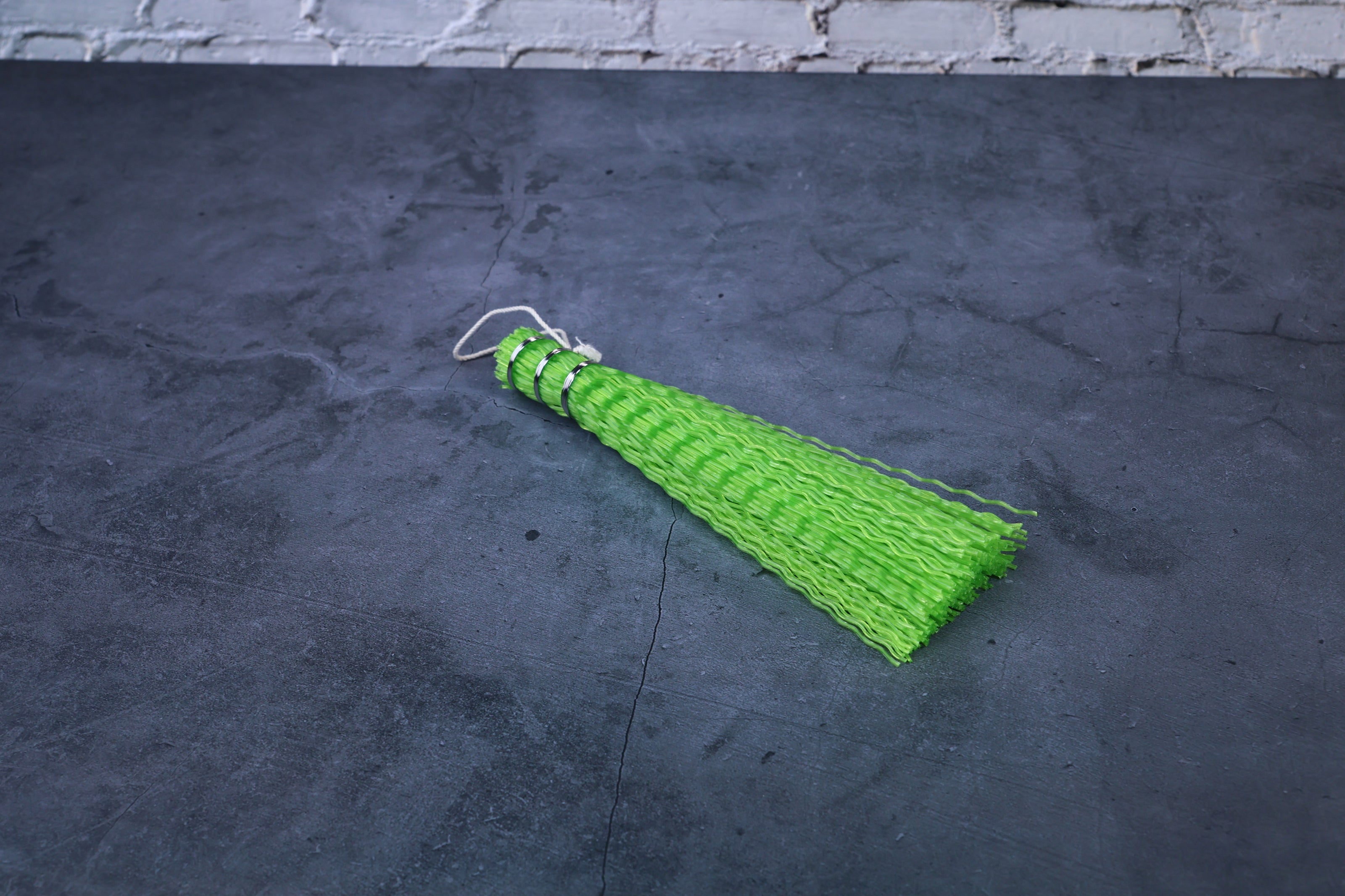 Hayakawa sasara fish cleaning brush — handle end showing wire binding, hanging loop, and bristle texture