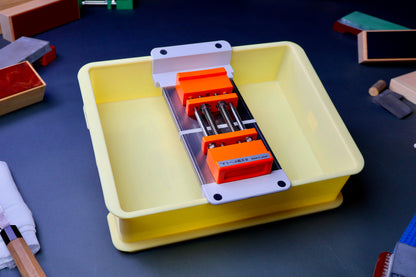 frontal colorful image of yellowish box holding sink bride and marie whetstone holder surrounded by knives towels knife strops rust erasers