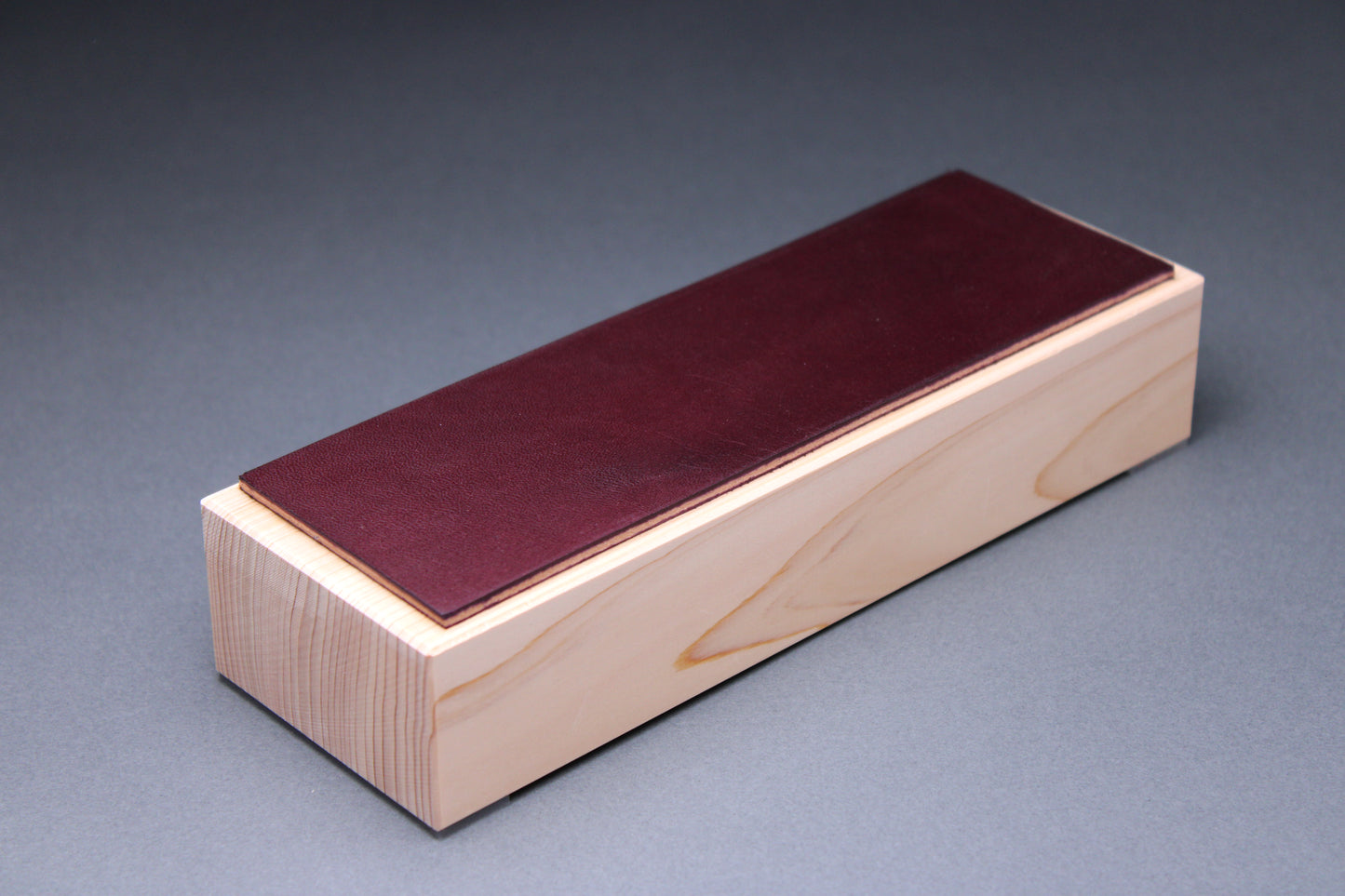 Hinoki plum leather knife strop — close-up of end showing plum leather thickness and hinoki wood grain