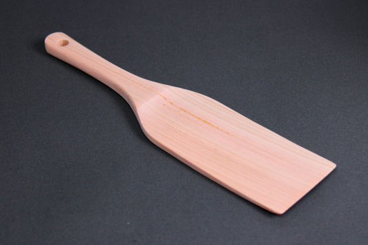 hinoki wood spatula long wide with thin handle and broad spatula area on dark grey surface