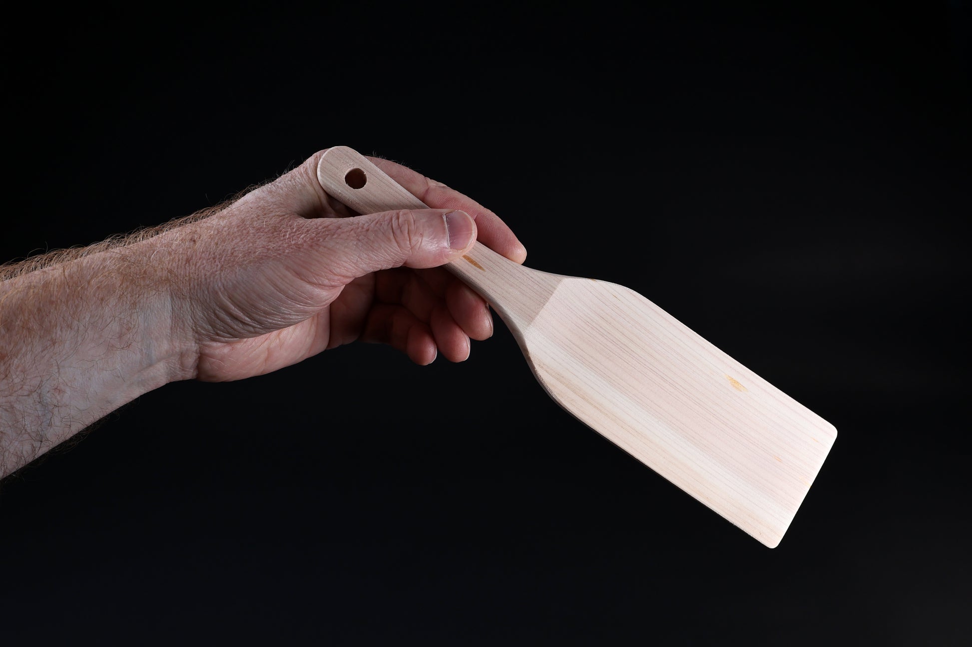 Hinoki wood spatula large — blade face and handle grip shown held in hand