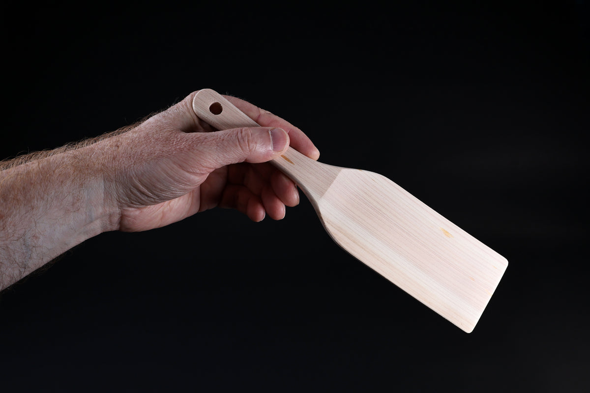 Hinoki wood spatula large — blade face and handle grip shown held in hand