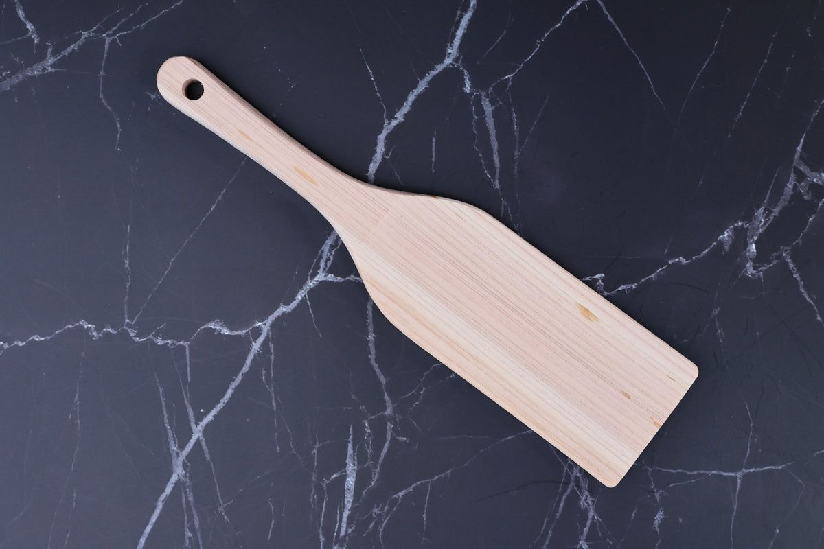 Hinoki wood spatula large — top view showing full blade, grain, and hanging hole on marble surface