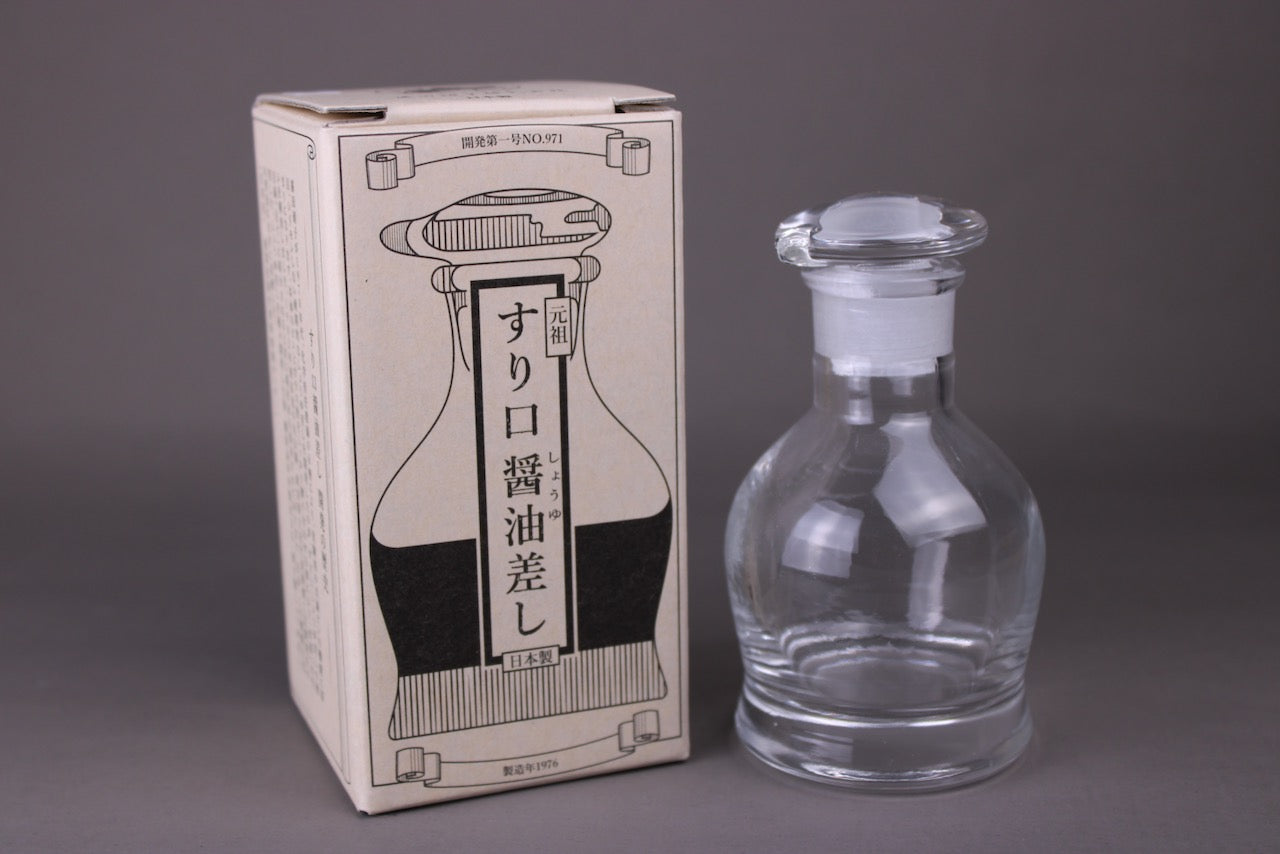 hirota glass original soy sauce cruet crystal with dispenser lid beside hirota package box with black ornate print of cruet and black text with grey background