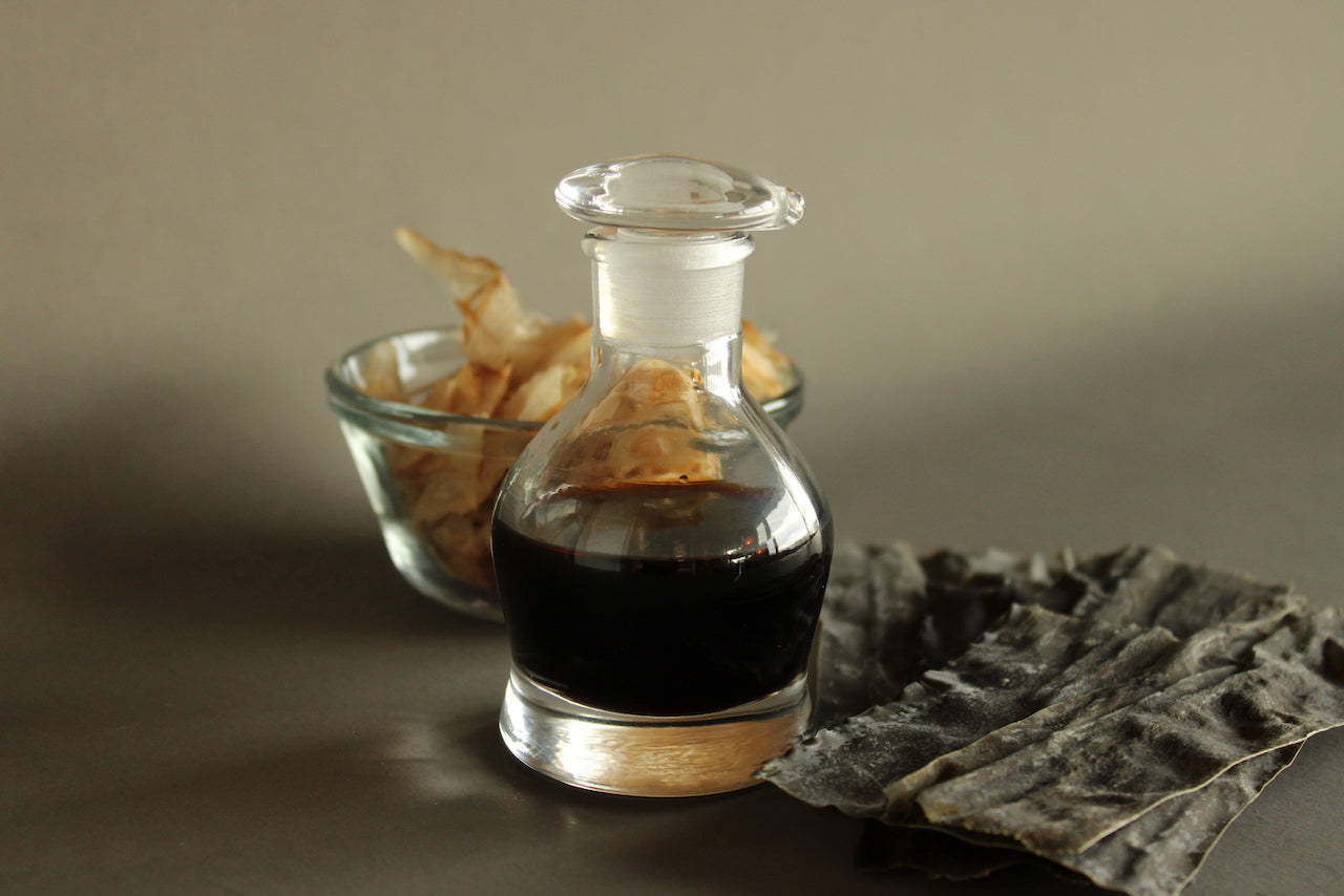 hirota glass original cruet filled with soy sauce beside glass container katsuobushi shavings and dried kombu for japanese kitchenware 