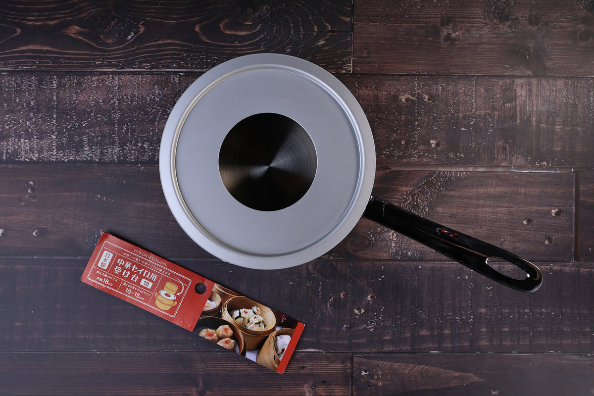 Hokuriku Aluminum steam ring 18cm — seated on single-handle pan, top view with red packaging