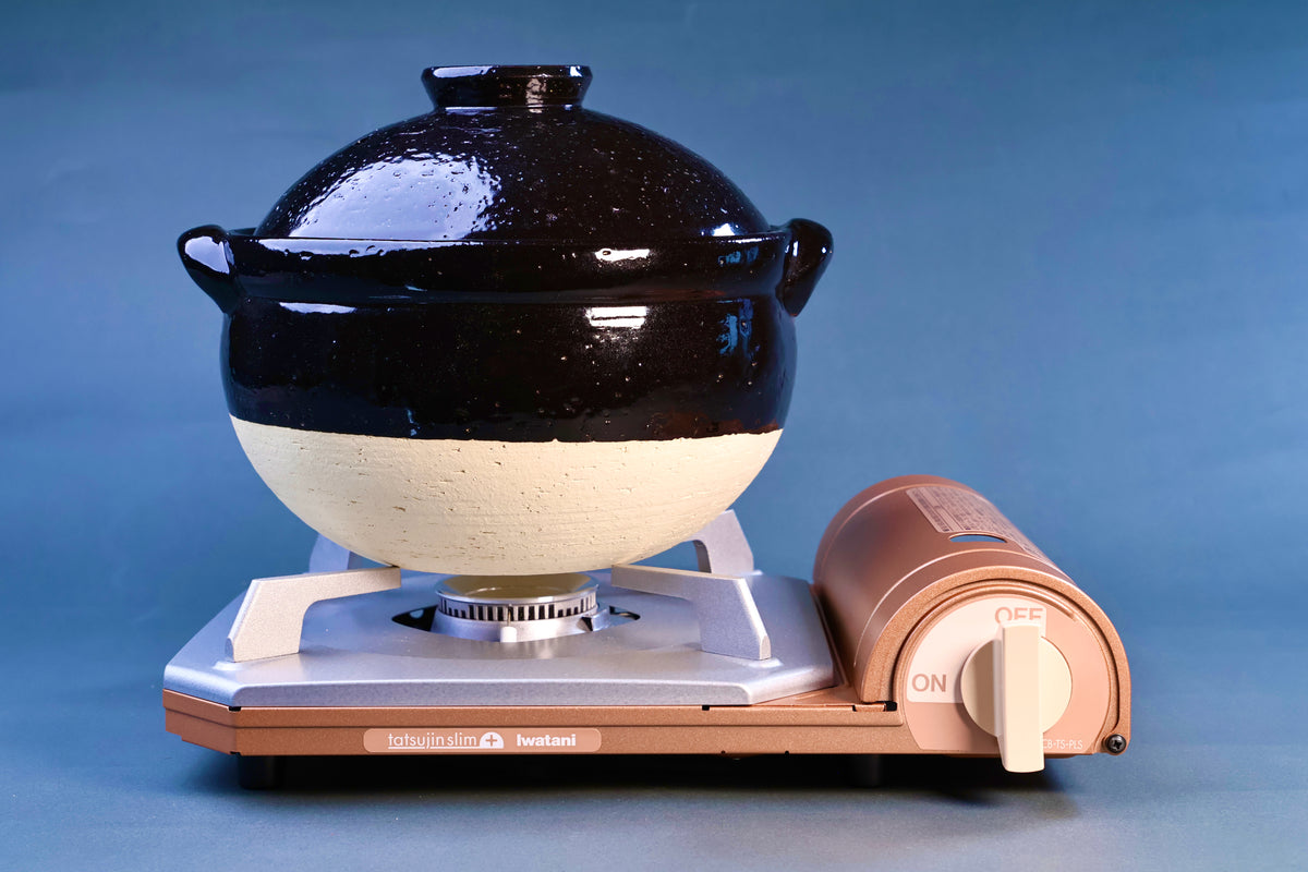 Iga Yaki rice donabe on Iwatani portable gas burner, showing full pot profile and two-tone glaze finish
