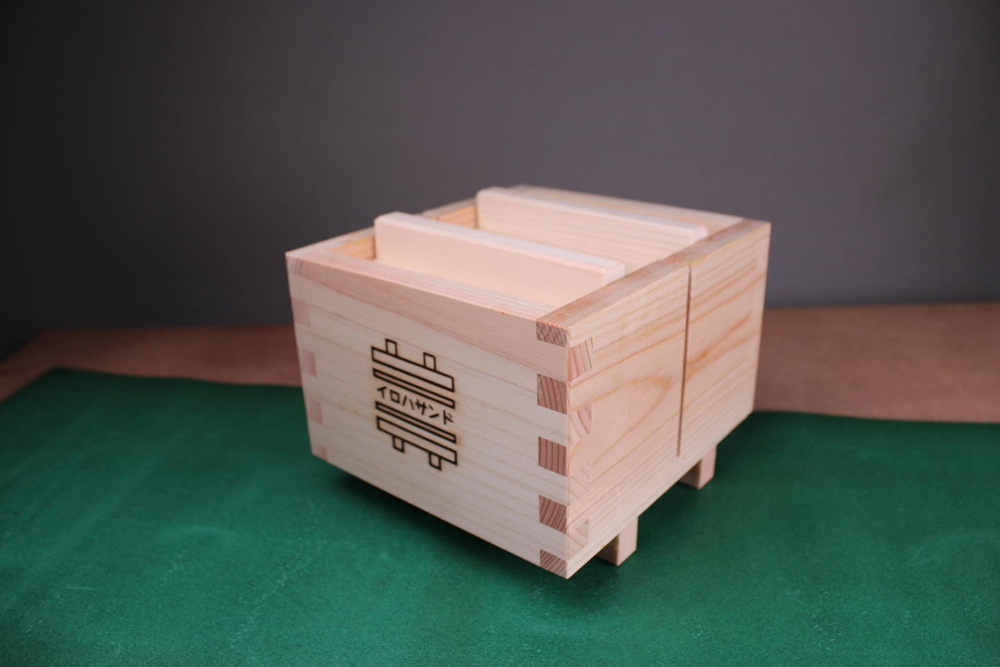 iroha sandwich maker by yamacoh made from hinoki wood atop green surface with grey background