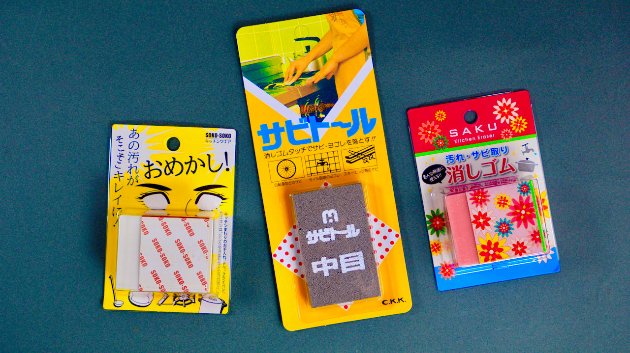 Three Japanese rust erasers in packaging: Soko-Soko white eraser blocks, Sabitoru medium rust block and Saku Kitchen Eraser on grey background