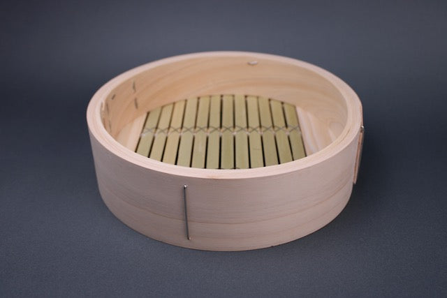 kiso hinoki base of chinese bamboo steamer round showing interior with stainless steel wired wrapped ring bamboo slats with grey background