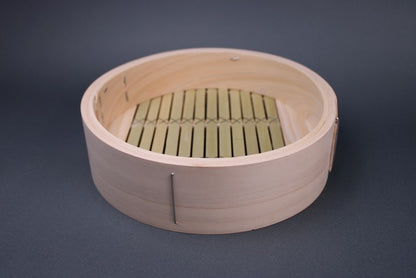 kiso hinoki base of chinese bamboo steamer round showing interior with stainless steel wired wrapped ring bamboo slats with grey background