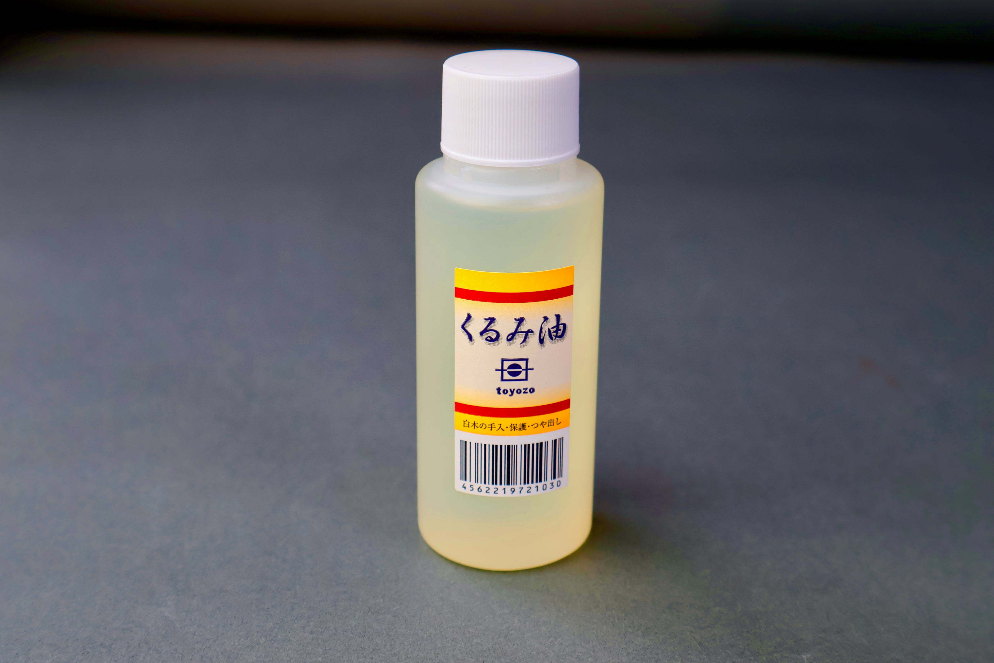 Small bottle kurumi oil with a label on a gray background