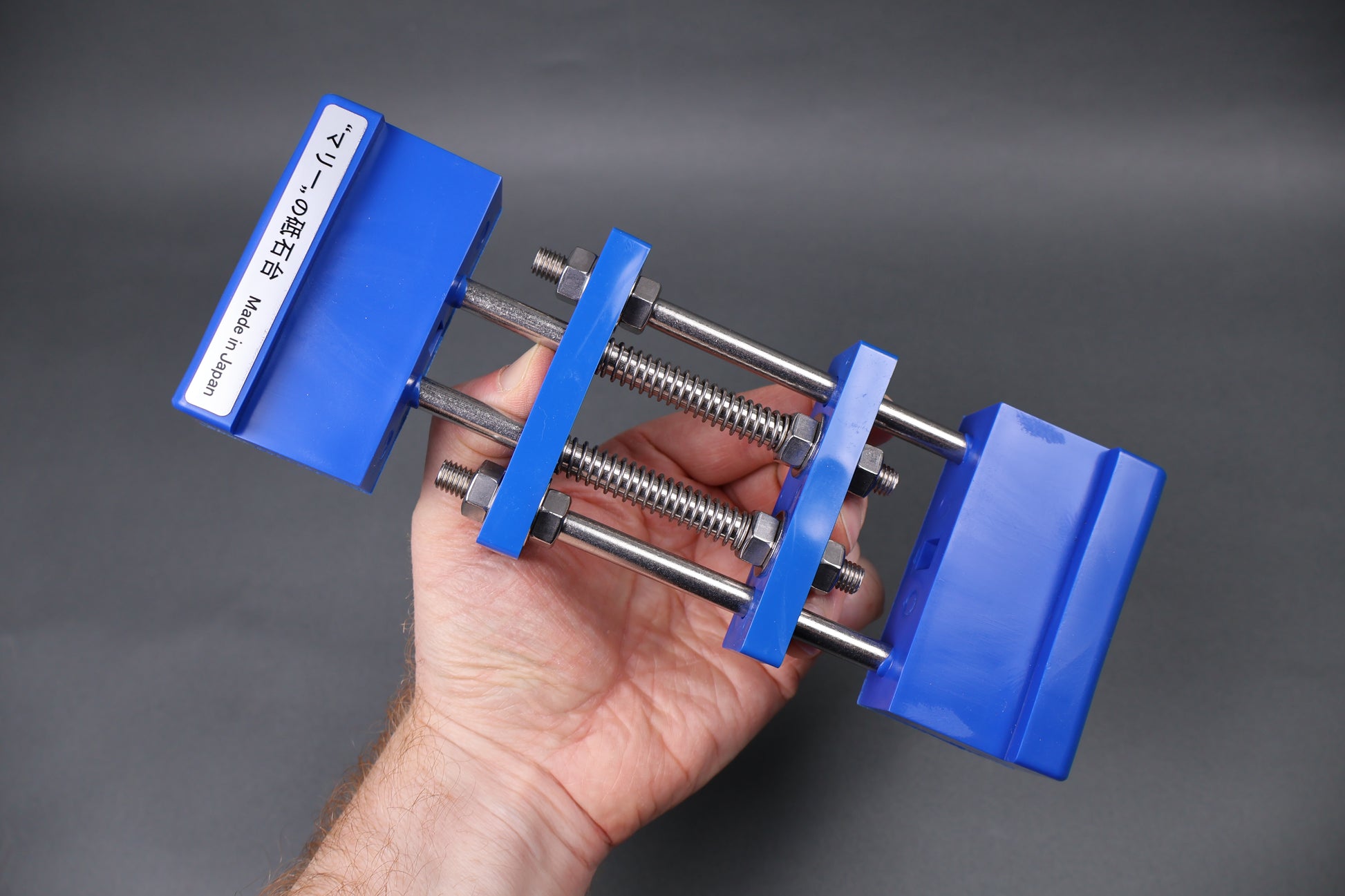 hand holding whetstone holder blue grey background