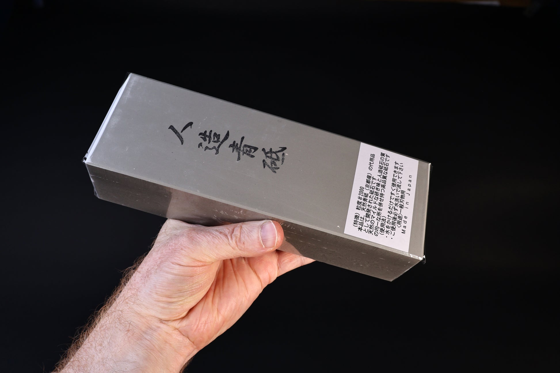 Jinzou Aoto #2000-4000 whetstone — in-hand view of label showing synthetic aoto and Made in Japan