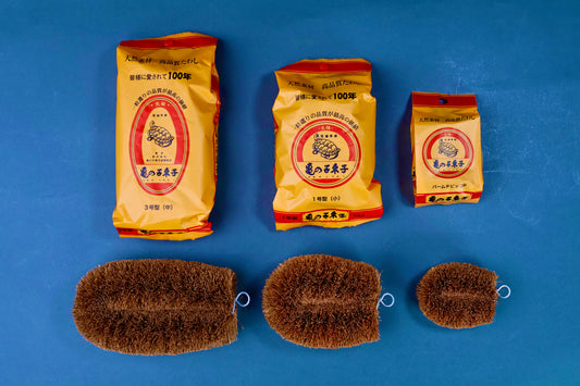 Kamenoko Tawashi three sizes — No.3 medium, No.1 small and Palm Piccolo — with packaging above each scrubber on blue background