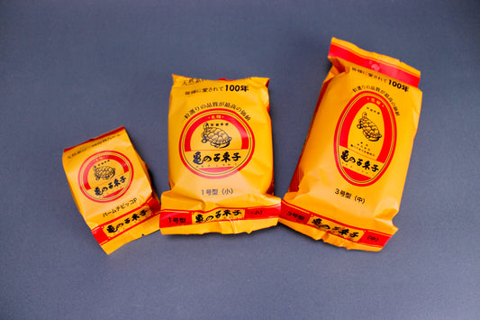 three yellow red plastic packages each with an animated image of a turtle with kanji characters on grey background