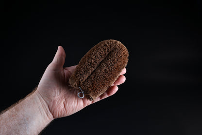 Kamenoko Tawashi No. 3 medium scrub brush — held in hand showing full oval form and bristle depth