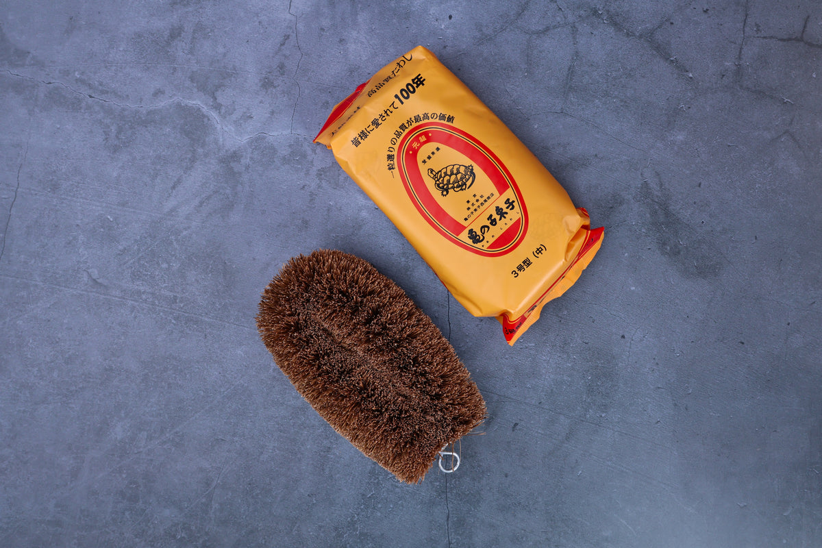 Kamenoko Tawashi No. 3 medium scrub brush — brush and original Japanese packaging flat lay