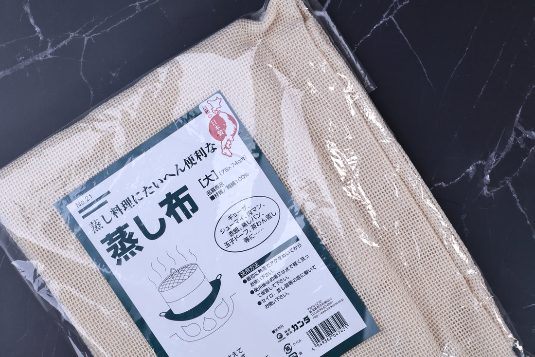 Kanda steamer cloth 78x74cm close view, label detail and open-weave cloth texture through plastic