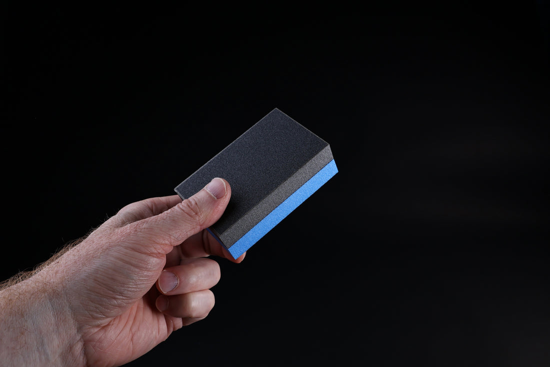 Kato Sangyo cutting board scraper — held in hand showing opposite side with fine and coarse abrasive face detail