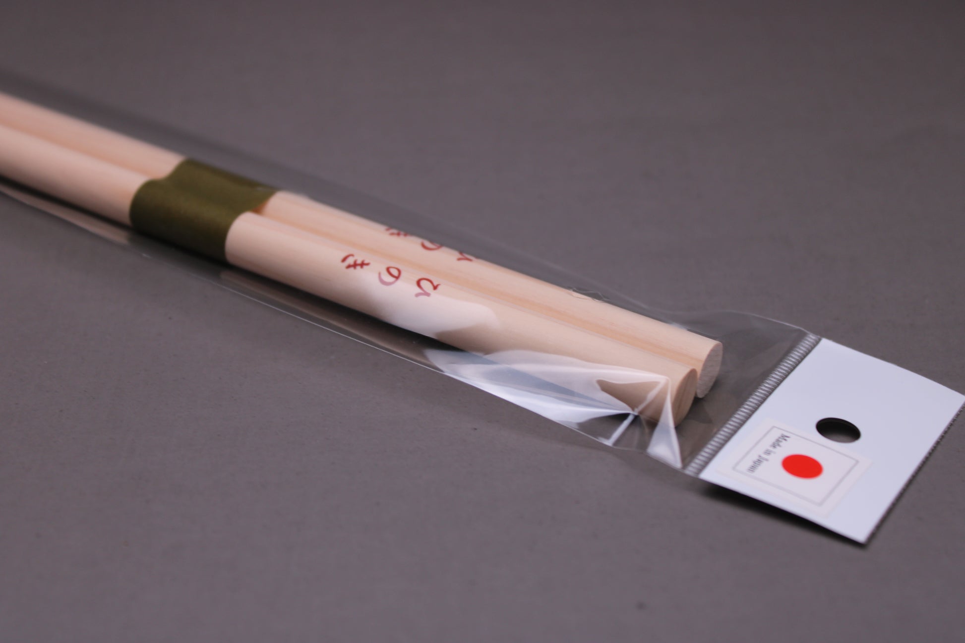 saibashi round cooking chopsticks by yamacoh youbi kisou life packed in clear plastic with red paper backing and sticker writing hinoki in hiragana with grey background closeup of top of package